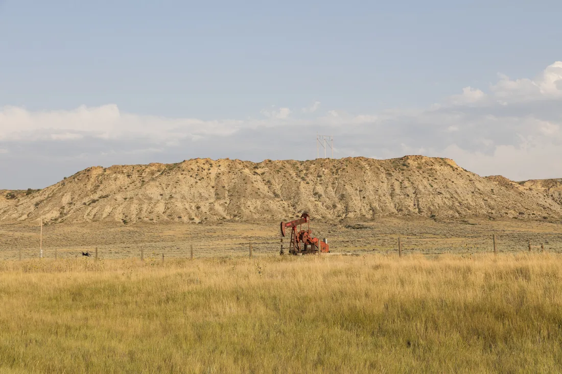 A single pumpjack working a field of dry grass in Converse County, Wyoming.